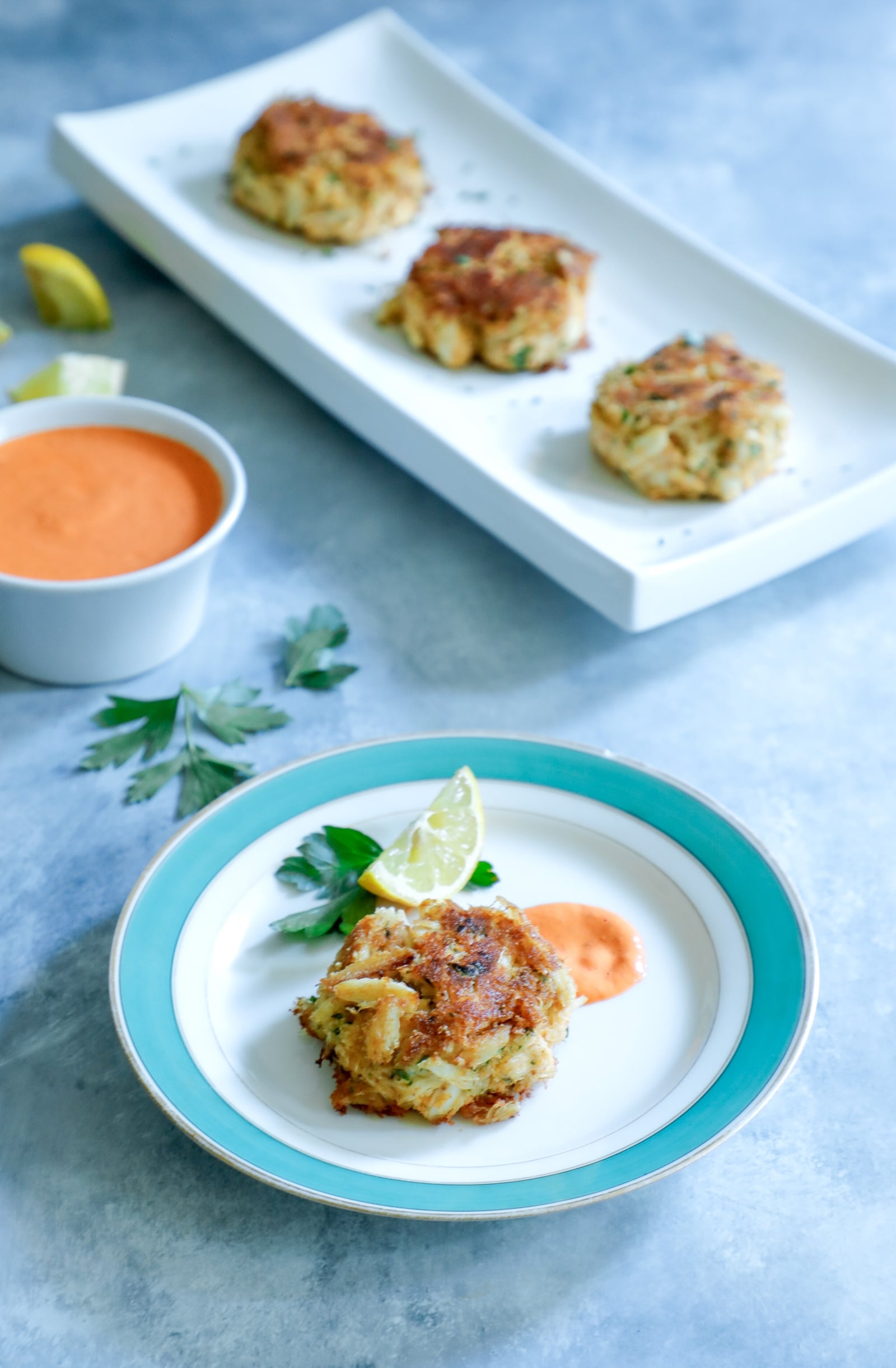 Keto crab cakes served with roasted red pepper sauce and lemon wedges.