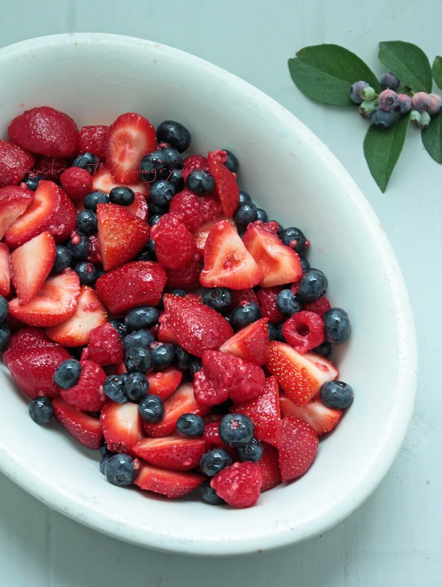 Bowl of cut of summer berries ready to top with meringue