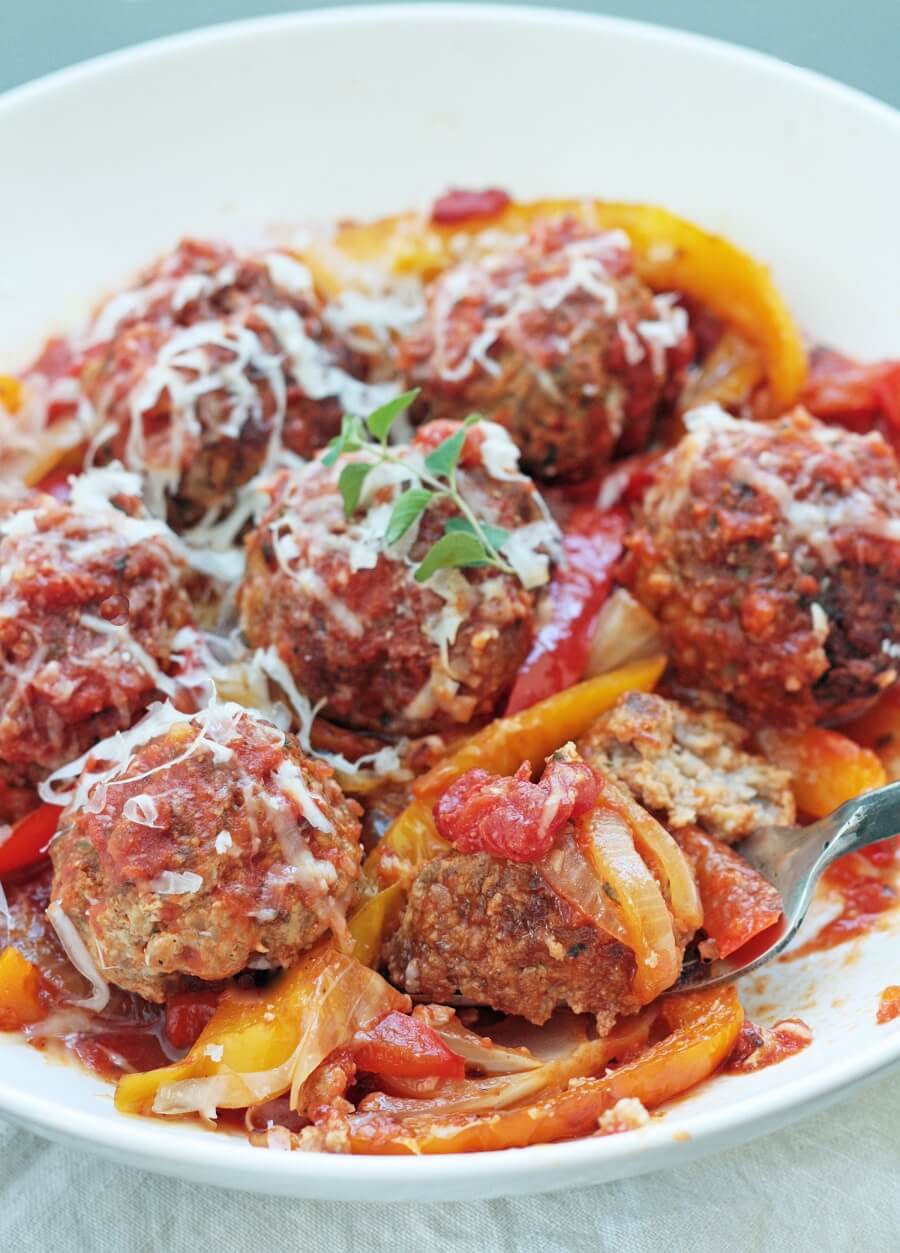 low carb sausage and peppers meatballs on a fork on a white plate