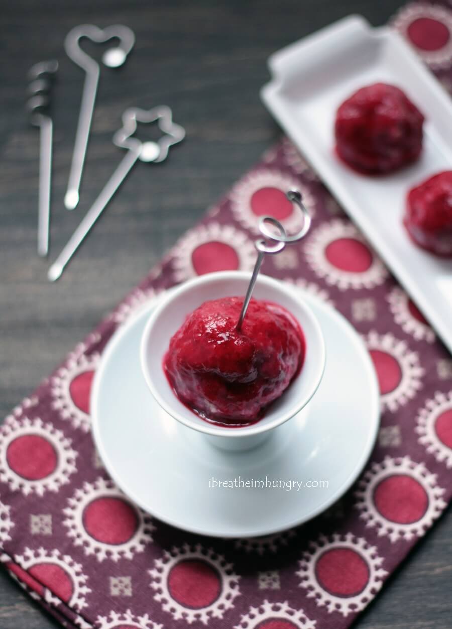 Turkey Meatball with Cranberry Glaze on a white dish with a cocktail skewer through the center
