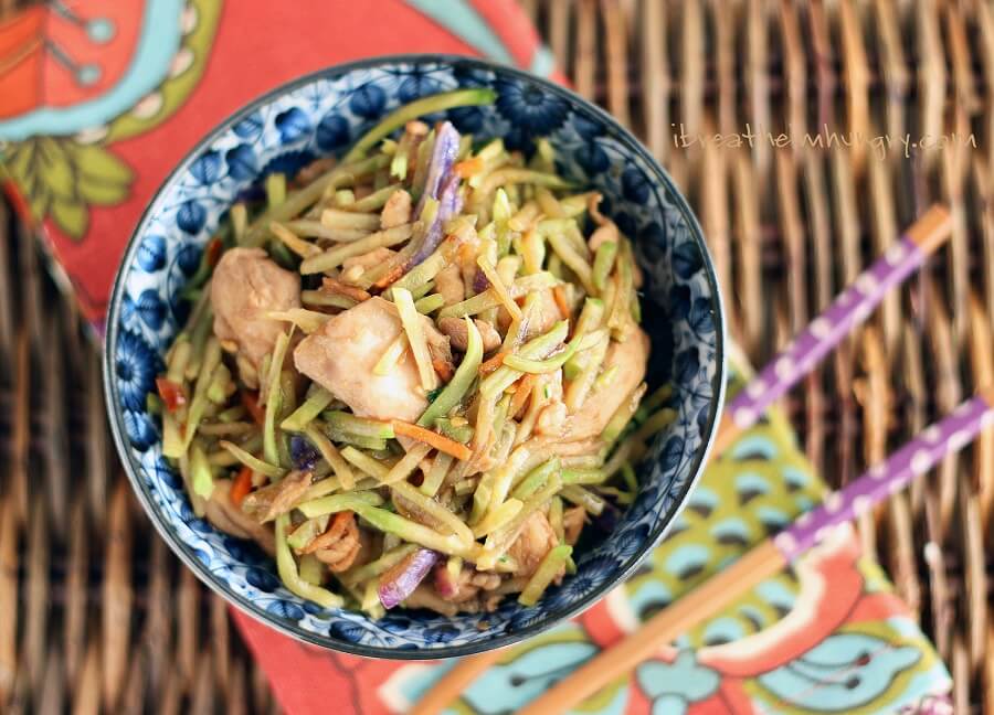 Keto Friendly Chicken Stir Fry Recipe on a bamboo mat with a napkin and chopsticks in the background.