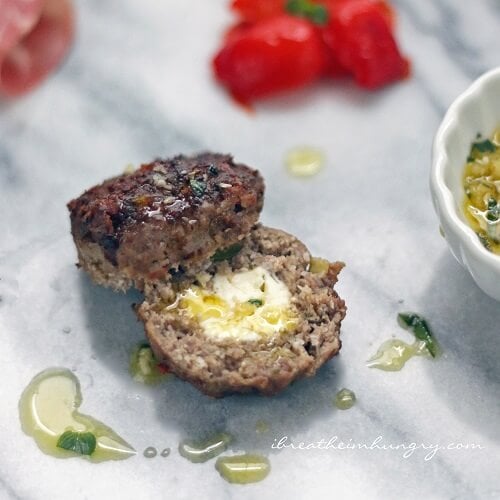 keto stuffed meatballs showing feta in the center and a drizzle of olive oil.
