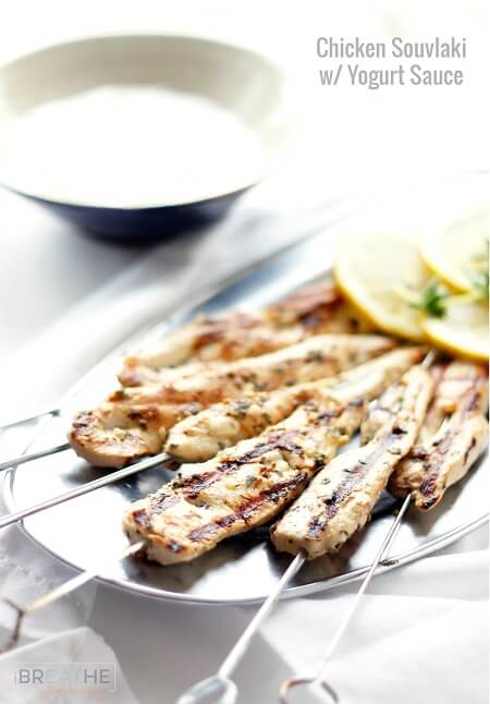 Grilled Chicken Souvlaki skewers with Yogurt Sauce in a blue pottery bowl