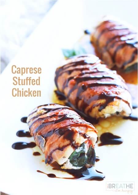 Keto Caprese Stuffed Chicken breasts on a white platter with a drizzle of balsamic glaze