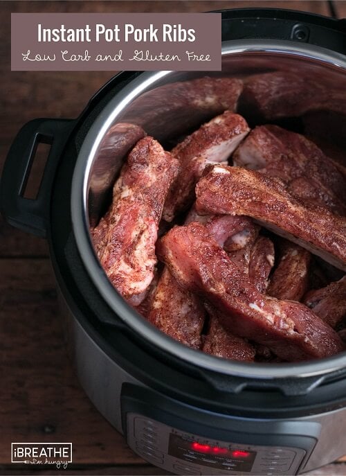 seasoned ribs added to the instant pot in layers, shown before cooking
