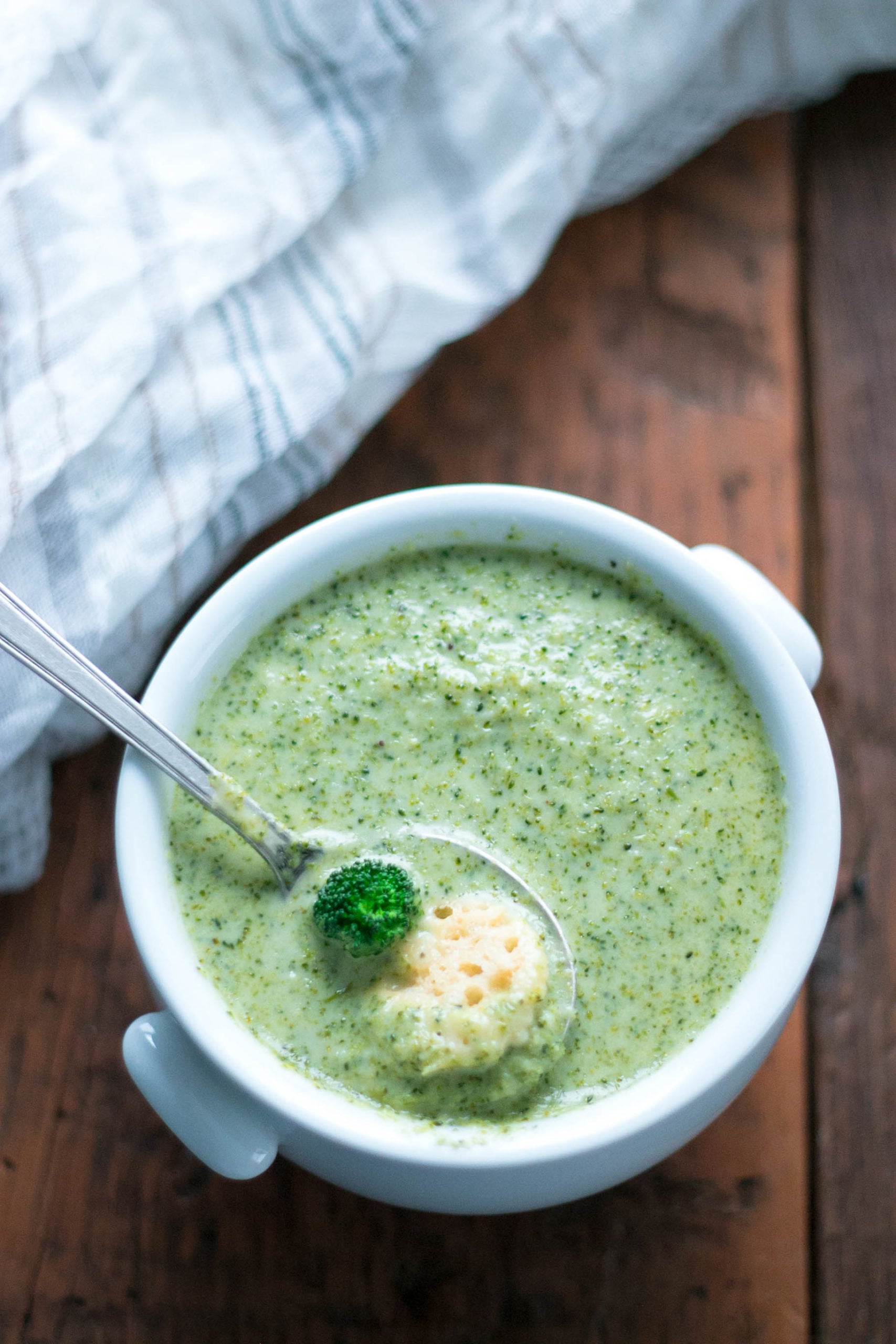 spoonful of keto broccoli cheddar soup with broccoli chunks