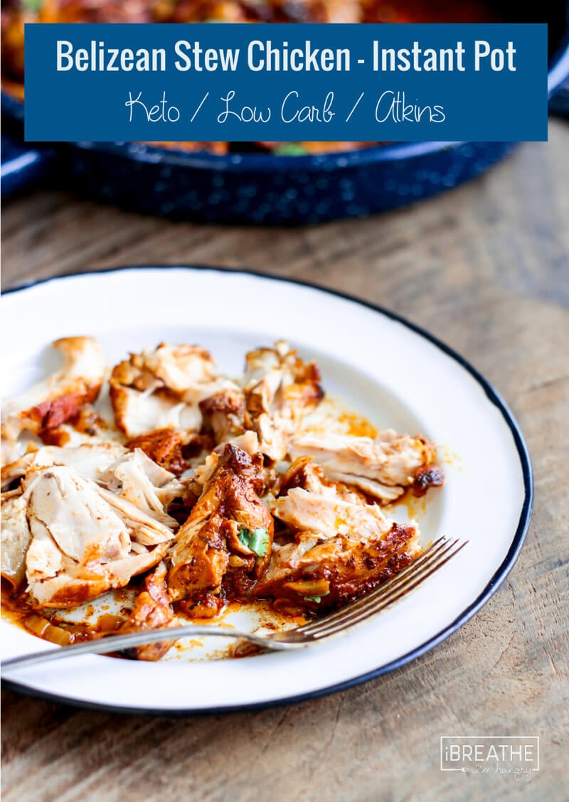 The tender meat of this Belizean stewed chicken flaked apart on a white plate