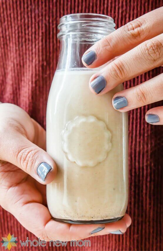 Woman holding sugar free pumpkin spice creamer in bottle