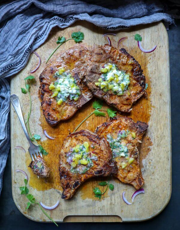 Keto Pork Chops al Pastor - four pork chops on a wooden cutting board