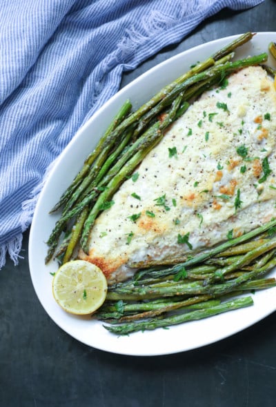 Keto Sheet Pan Salmon & Asparagus with lemon wedges on a white platter