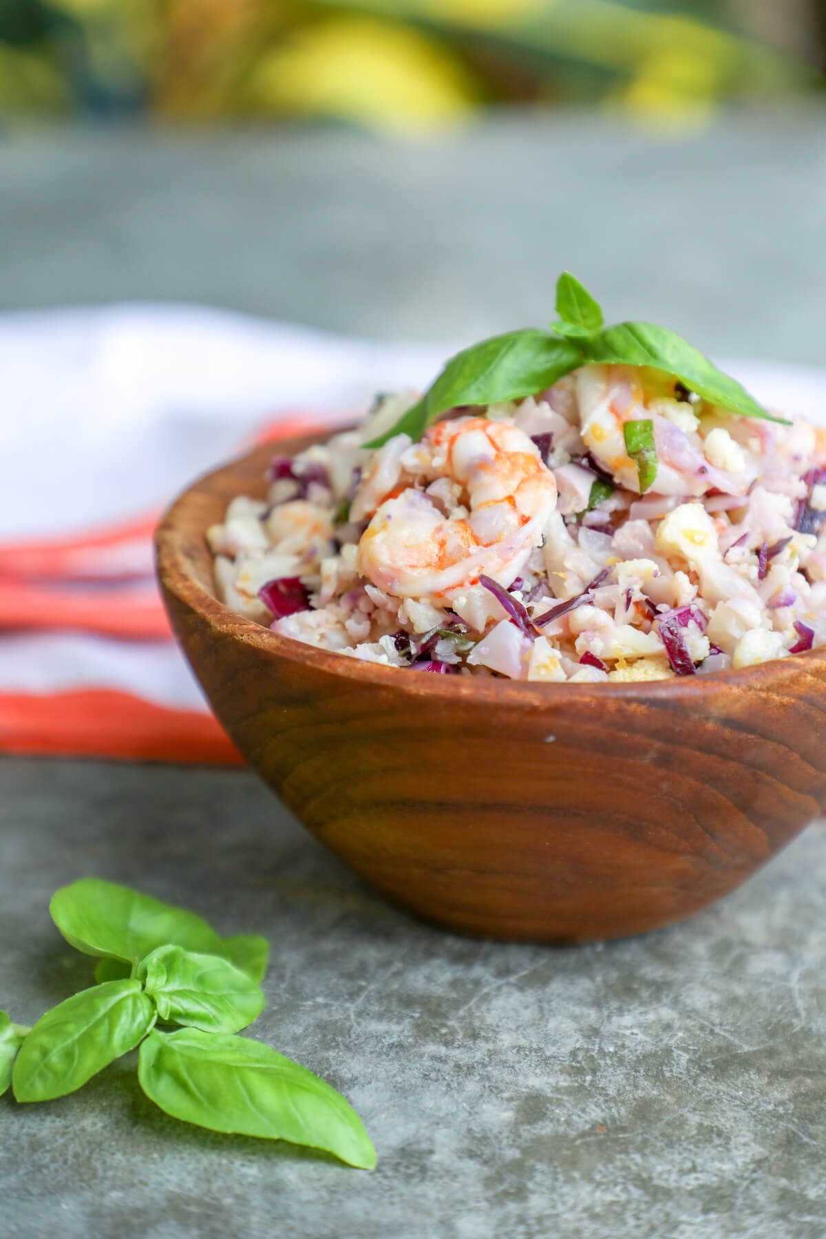 keto shrimp salad with basil in a wooden bowl with a basil garnish