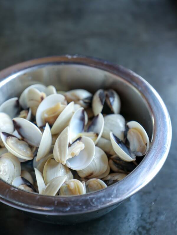 Stainless bowl of baby clams in shells