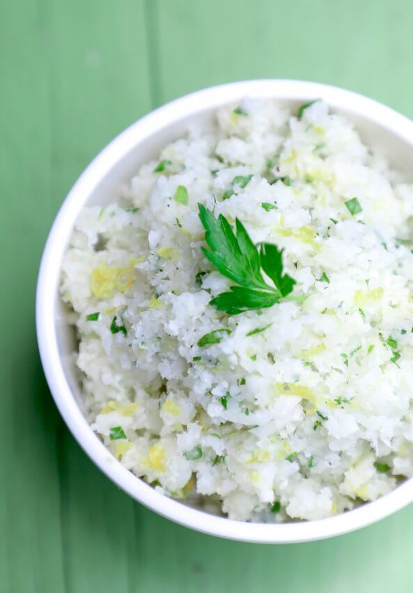 Keto Cauliflower Couscous in a white bowl on a green background from above