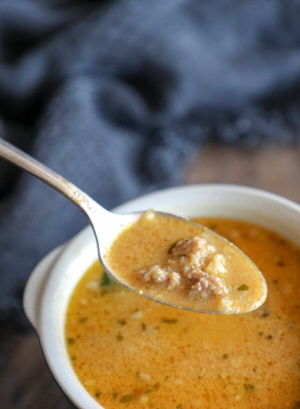 Creamy Keto Pumpkin & Sausage Chowder front view on a silver spoon