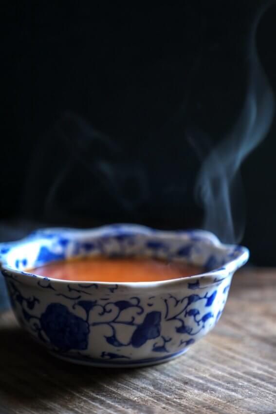 keto roasted tomato & garlic soup in blue and white bowl with steam rising