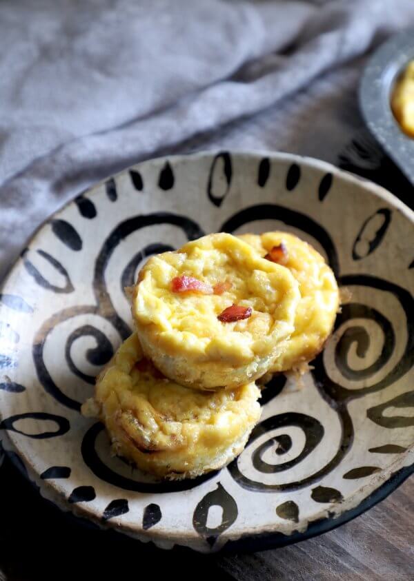Keto Bacon & Egg Onion Cups piled on a patterned plate