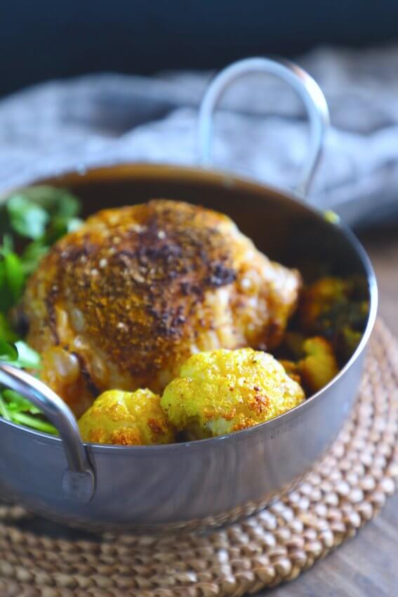 Keto sheet pan curried chicken - SCKC in a metal bowl on a woven natural reed mat