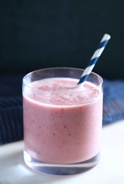 Keto Strawberry Vanilla Smoothie in a glass with a blue and white straw
