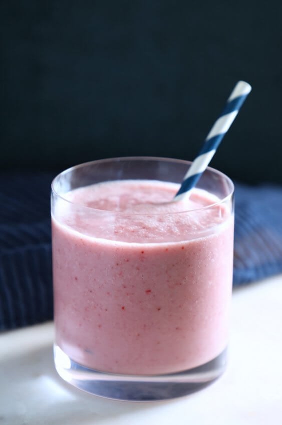 Keto Strawberry Vanilla Smoothie in a glass with a blue and white straw