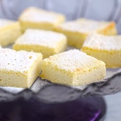 side view of Keto Lemon Magic Custard Cake on a purple cake stand