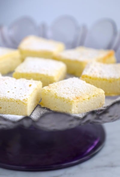 side view of Keto Lemon Magic Custard Cake on a purple cake stand