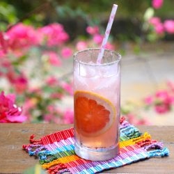 Keto Paloma Cocktail with pink flowers in the background