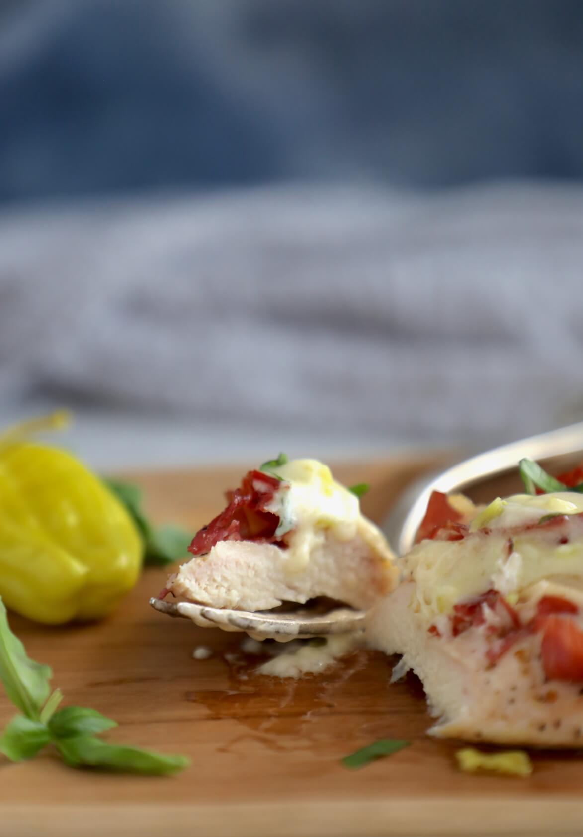 Forkful of Keto Hasselback Chicken with a grey napkin