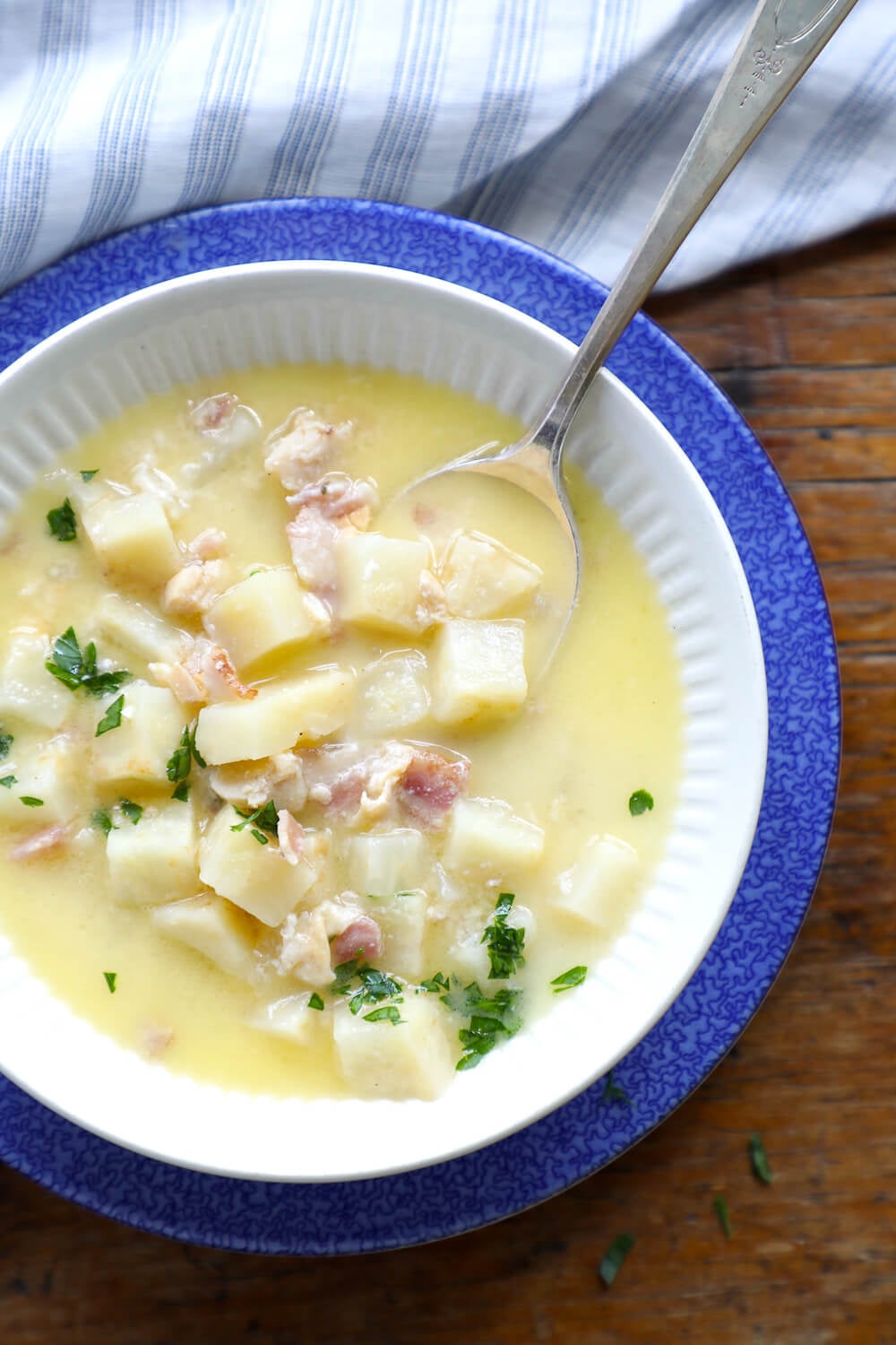 White bowl of keto clam chowder on a blue plate