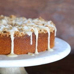 keto pumpkin chai coffee cake on a white pedestal with a blue napkin below it