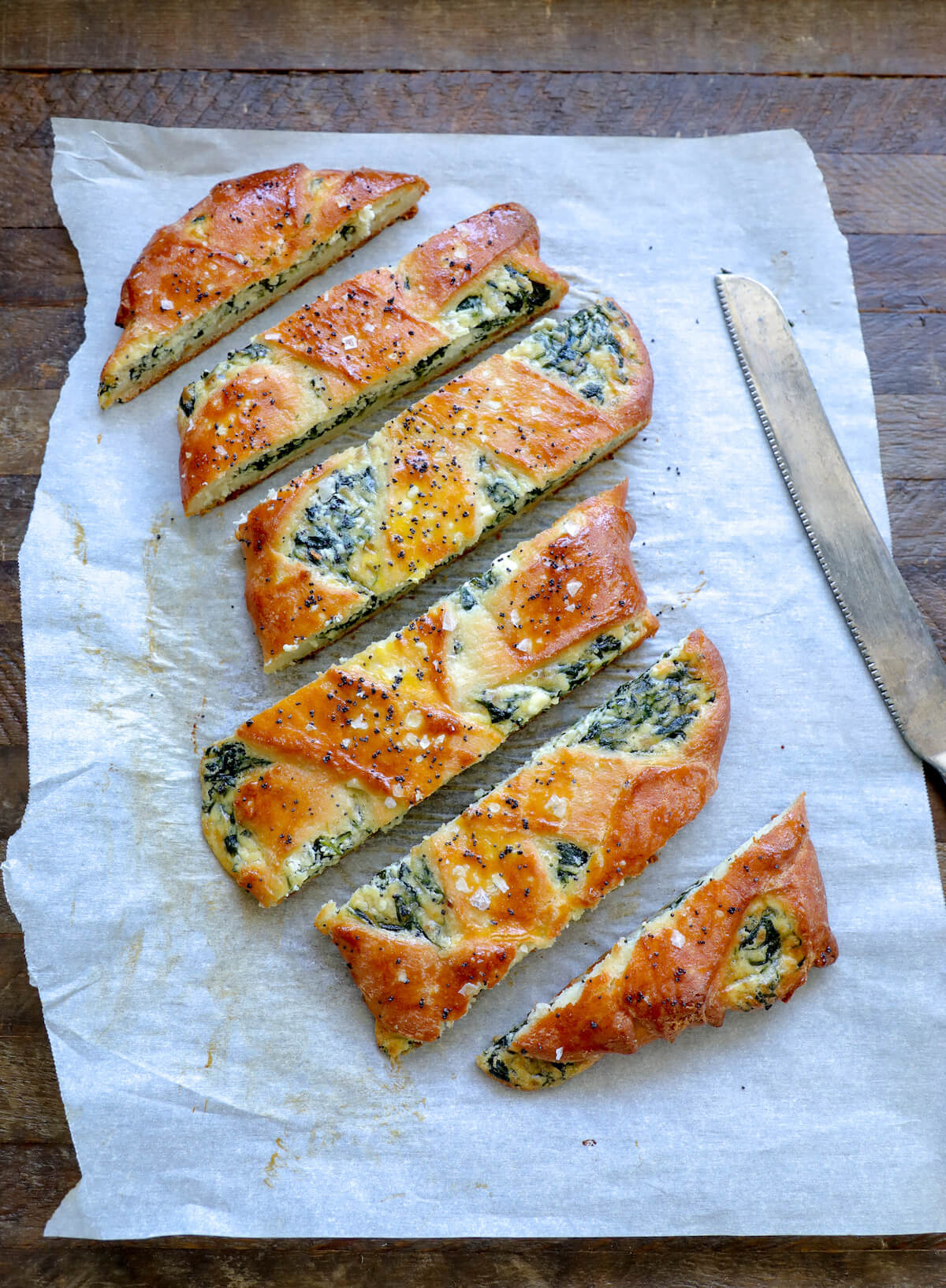 slices of keto spinach calzone on a piece of parchment paper