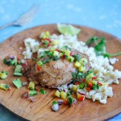 Keto Jerk Chicken Sheet Pan Meal on a wooden plate against a baby blue background