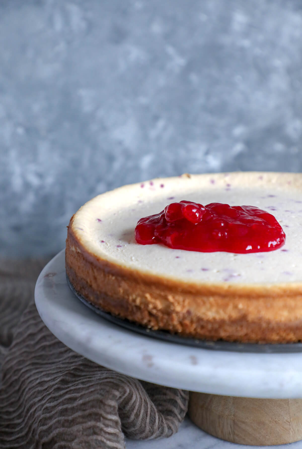 Process Shot of Keto cranberry orange cheesecake with the cranberry jelly spooned over the top