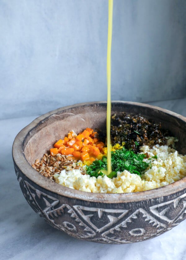 pouring the dressing over Keto Roasted Cauliflower Couscous