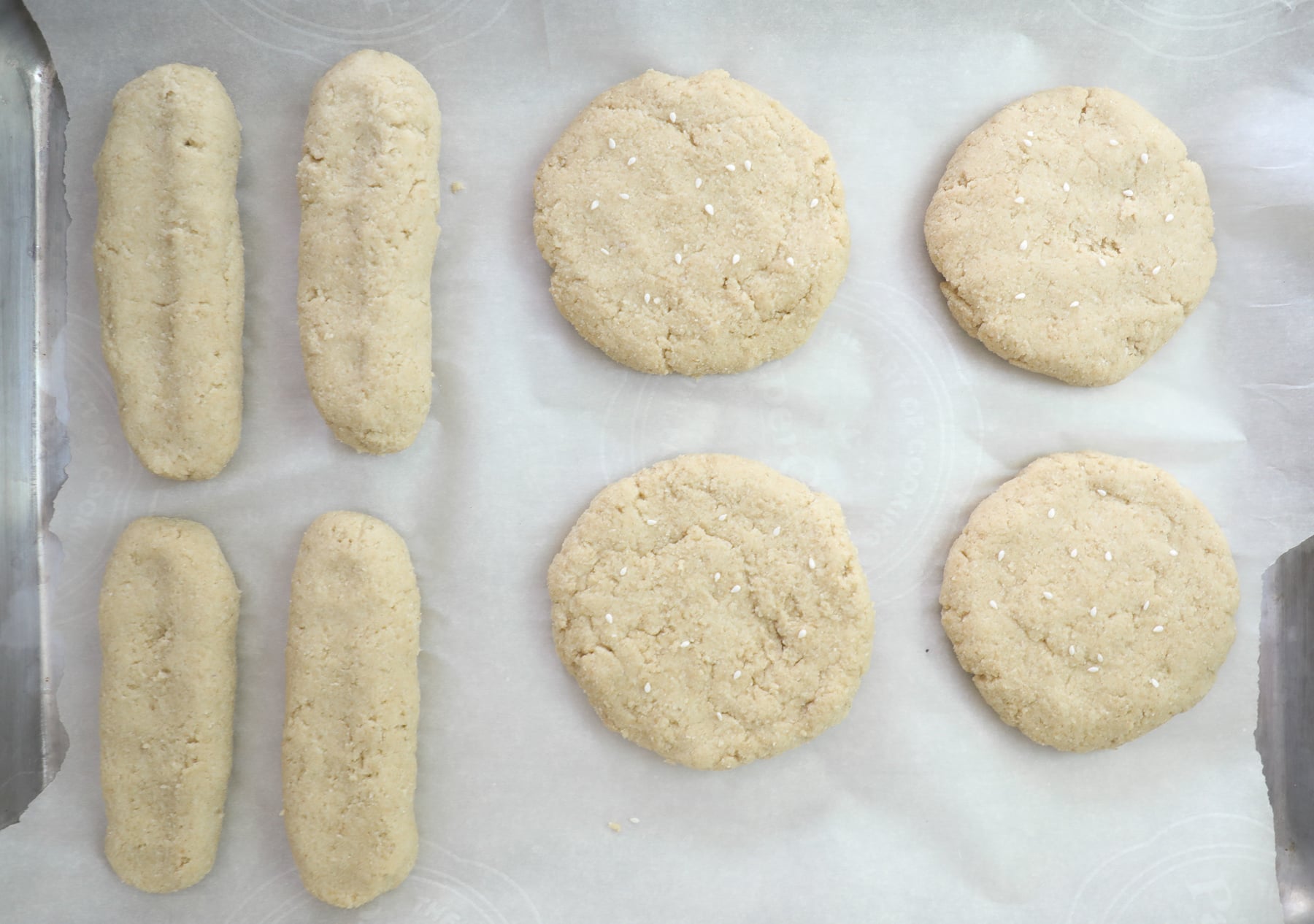 Unbaked keto burger buns on parchment paper