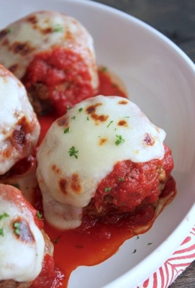 Keto Meatballs with marinara sauce, melted mozzarella cheese, and a sprinkle of parsley