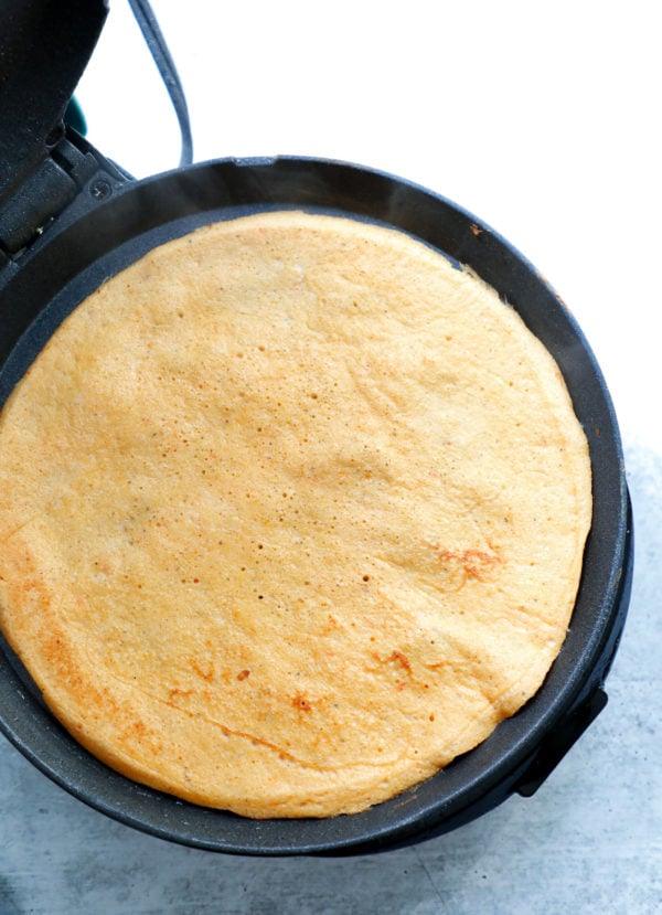 Keto Sandwich Wraps cooking on a dash griddle shown after flipping