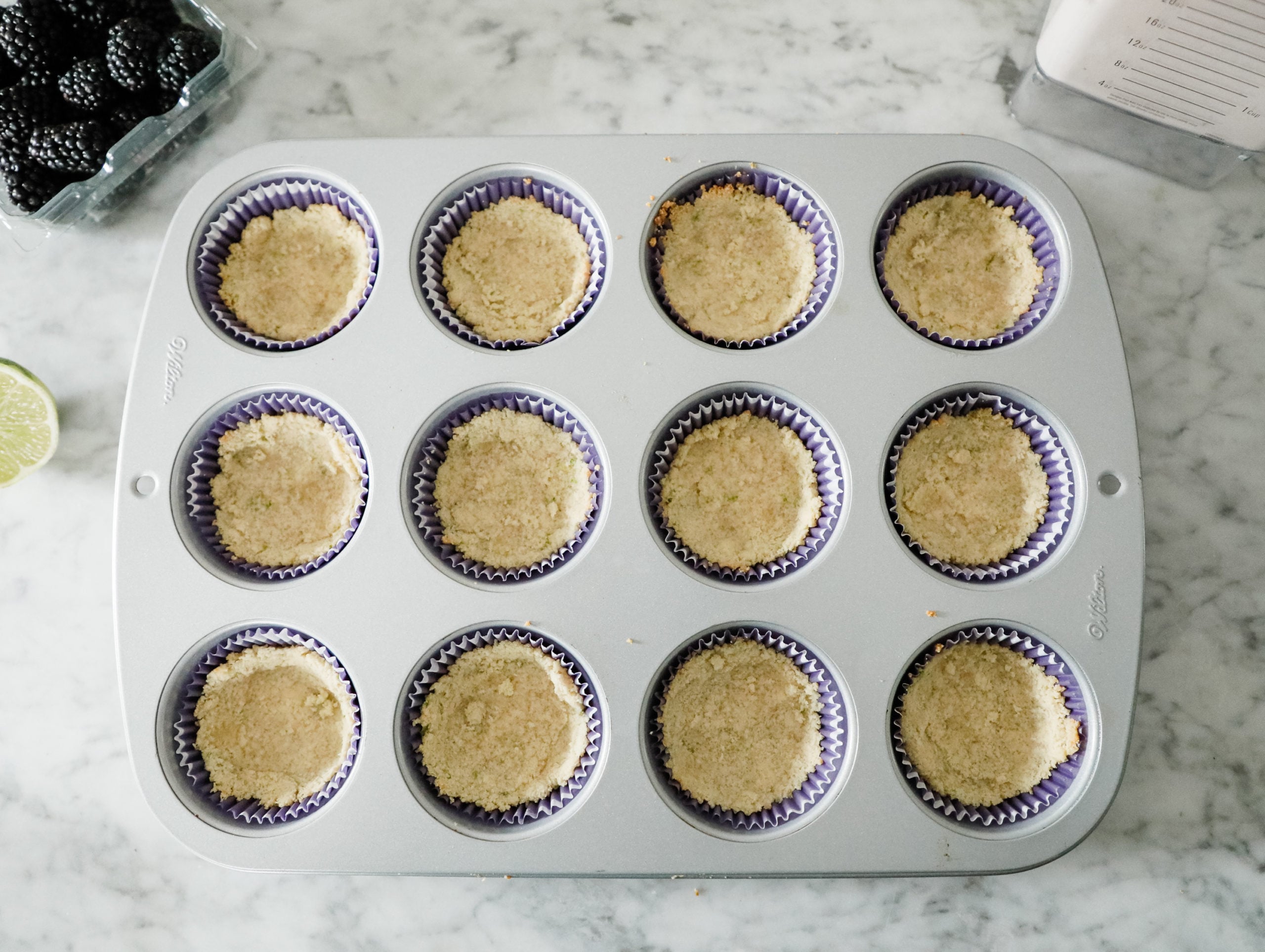 cupcake liners with pre-baked lime shortbread crust at bottom