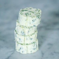 slices of maitre de butter or hotel butter stacked on a marble slab