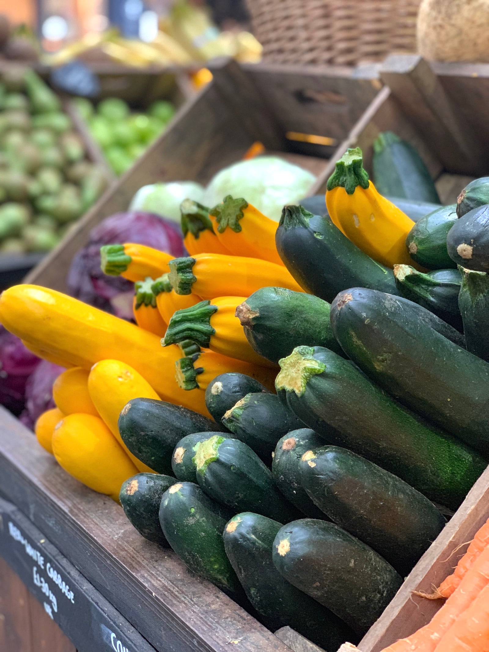 Green and Yellow zucchini stacked in boxes at a market