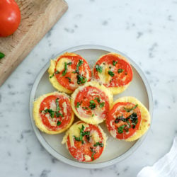 6 high protein egg bites arranged on a grey plate on a marble background.