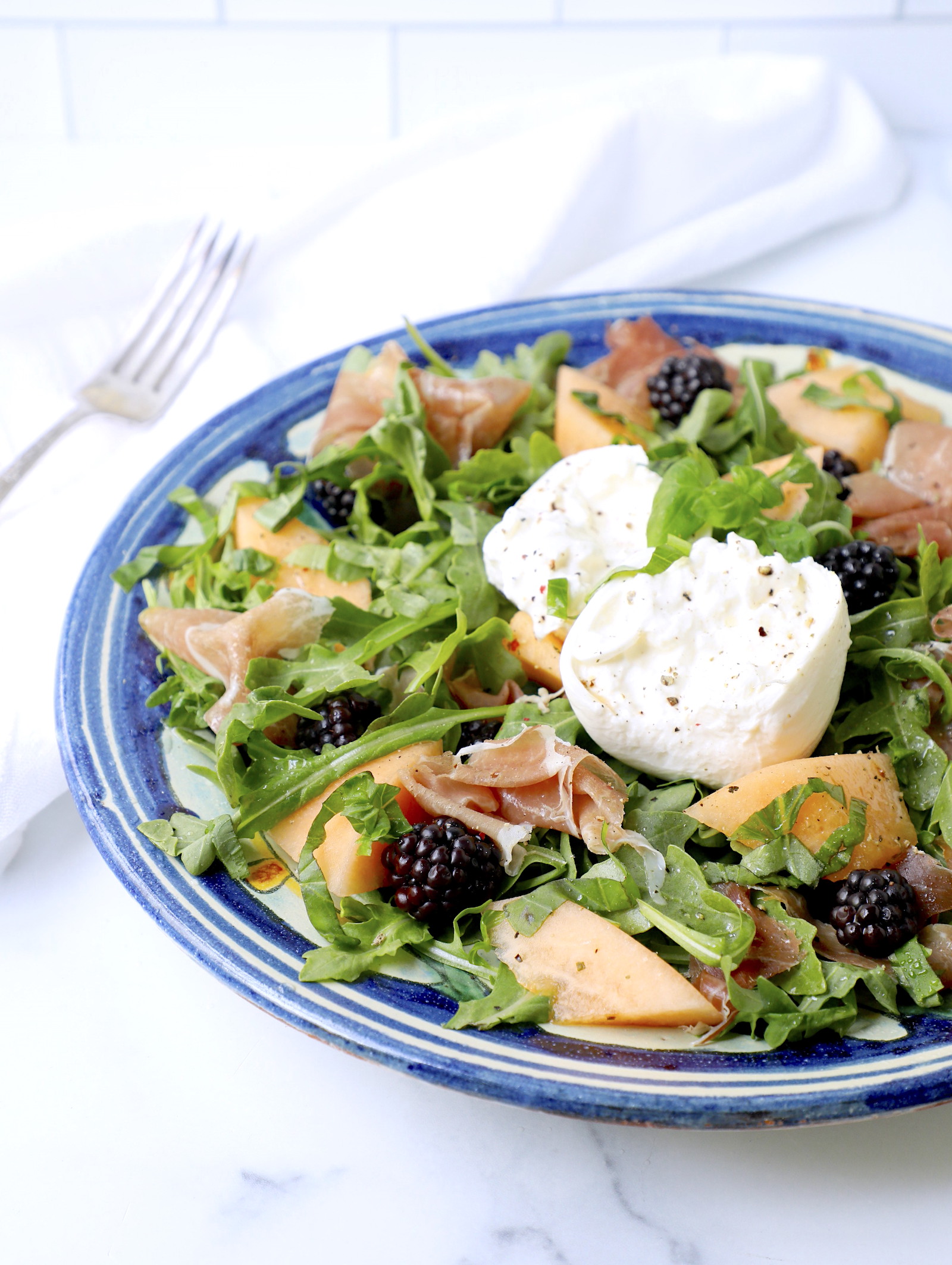 arugula and burrata salad shown with no dressing so you can see the other ingredients clearly.