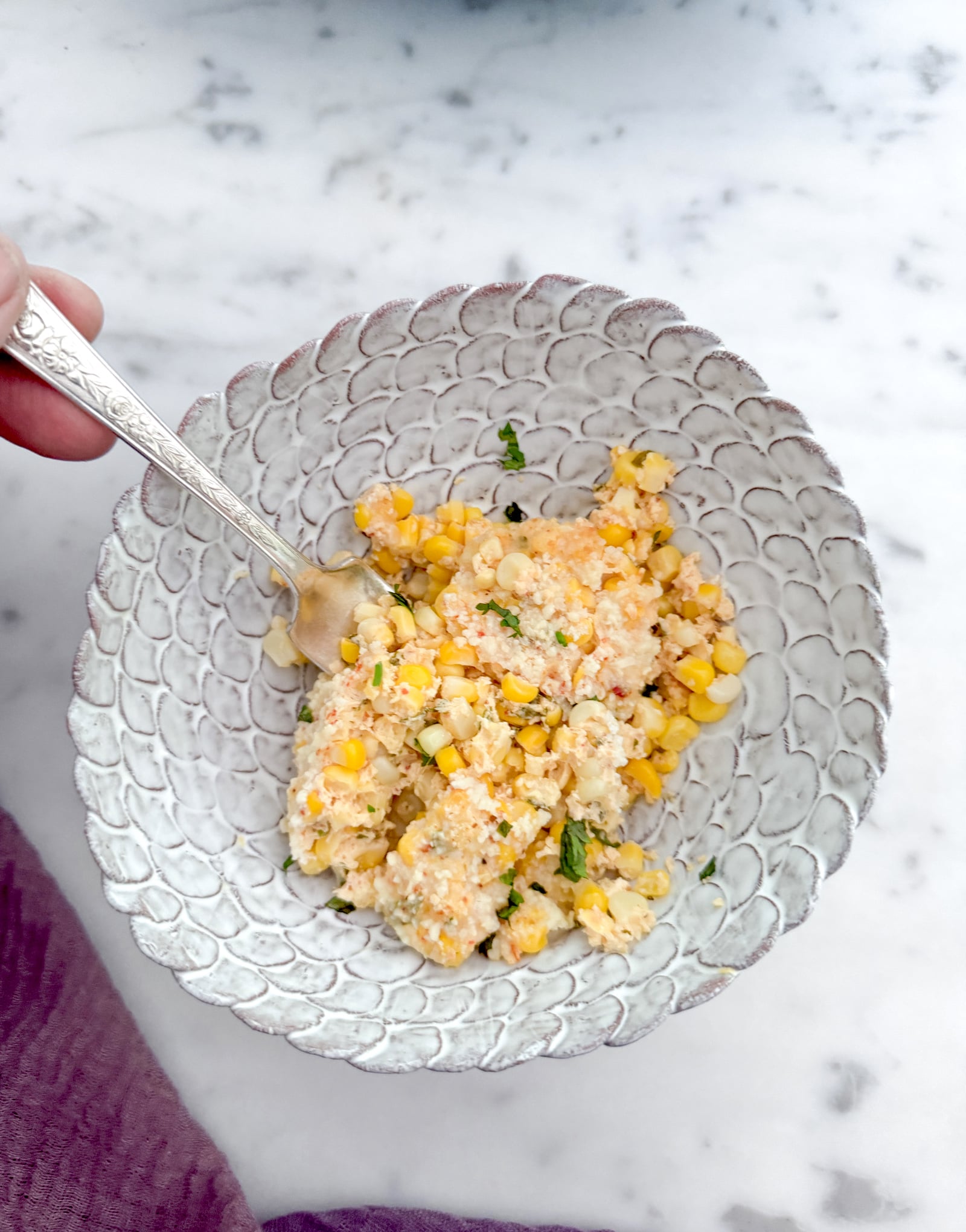 Forkful of street corn casserole in a white pottery bowl