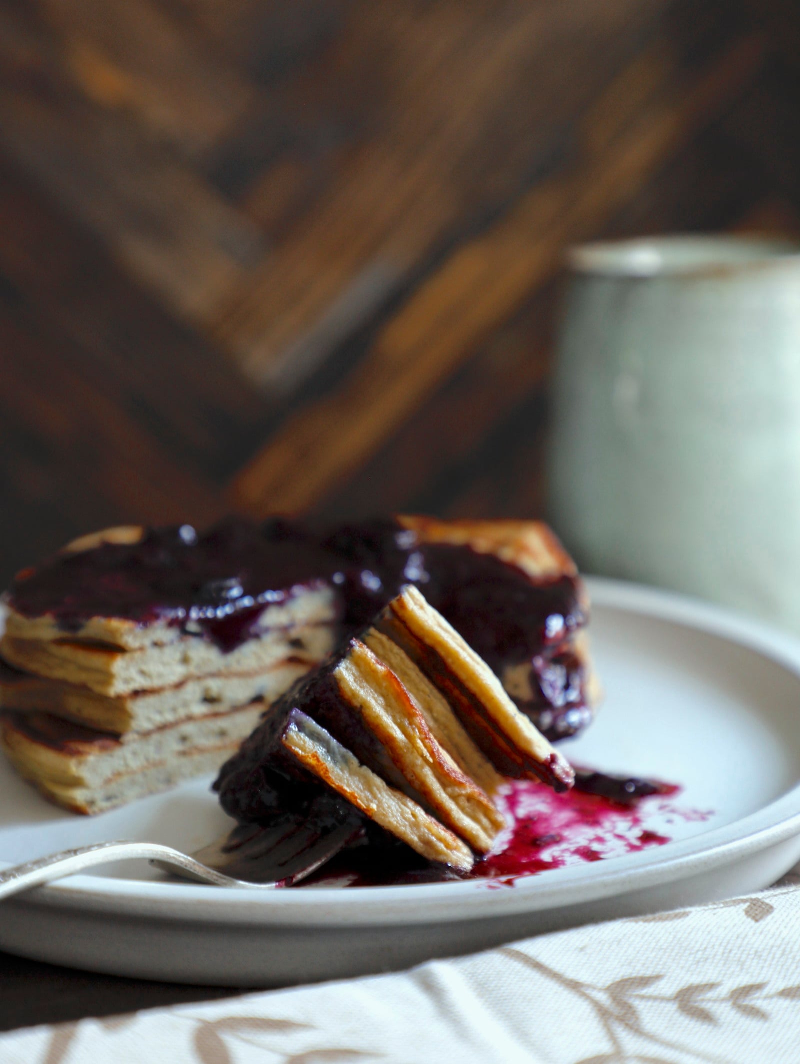 triangle shaped bite of a stack of keto pancakes on a fork with berry compote.