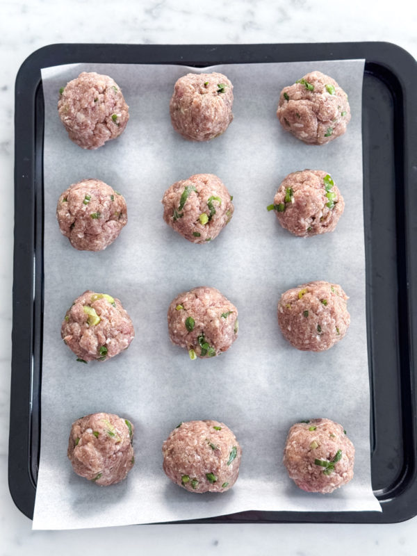 Korean Beef Bulgogi Meatballs on a parchment lined baking tray before going into the oven to bake.