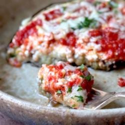 A forkful of high protein low carb eggplant parmesan with marinara, cottage cheese, and mozzarella cheese on top.